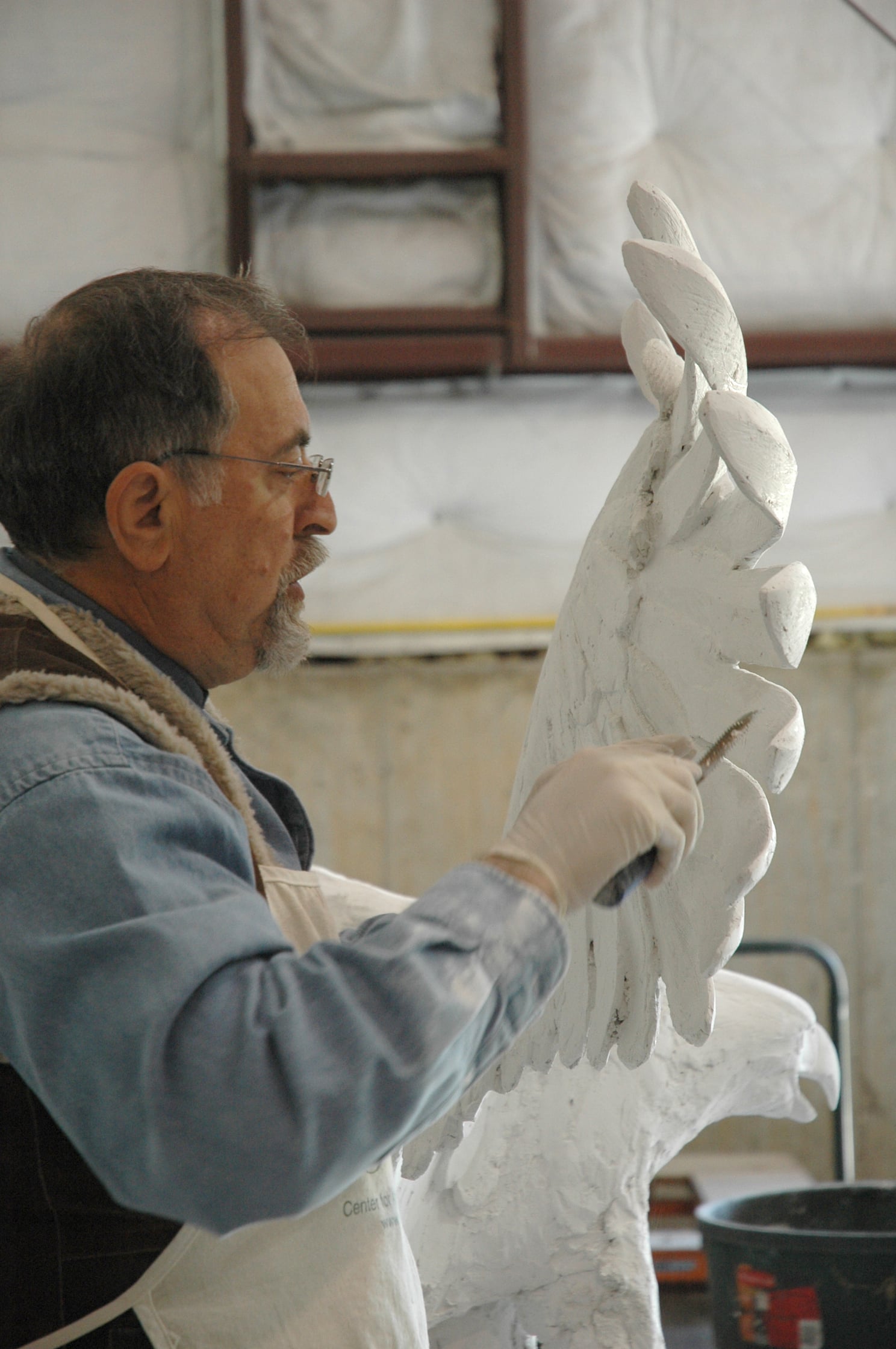 Alex is seen shaping details in the plaster that formed the base for the eagle sculpture.